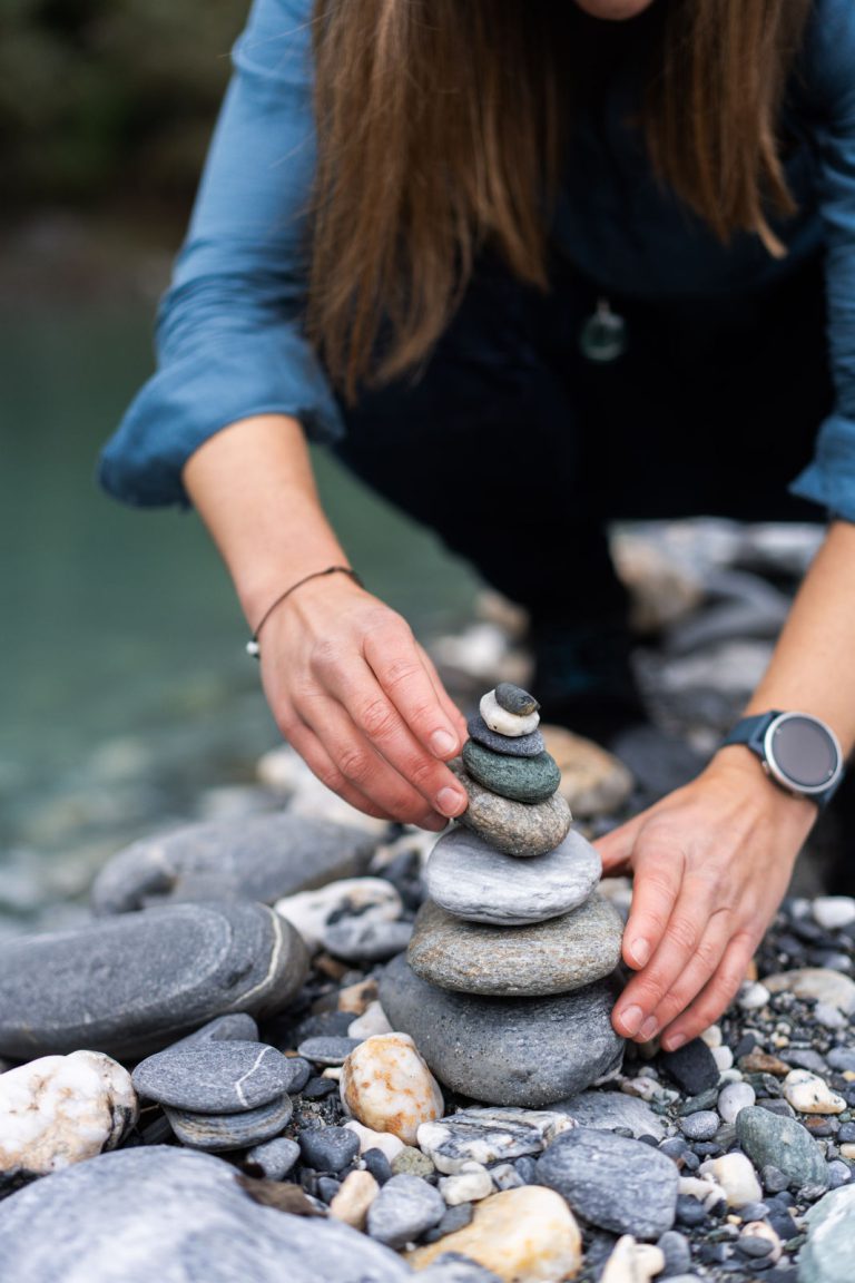 Manuela Gees, Therapeutin bei FASZIMA in Chur, baut ein Steinmännchen – Symbol für die harmonische Balance von Körper, Geist und Seele in der Therapie.